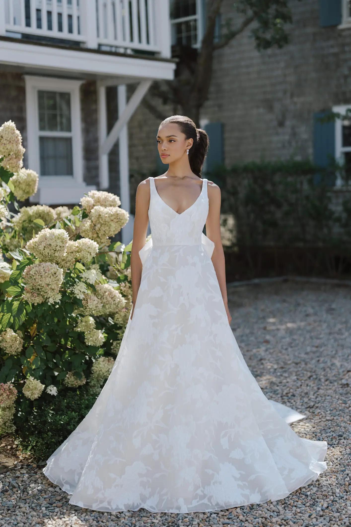 Liberty wedding dress by Anne Barge with v neckline floral detail ballgown skirt and bow on the back