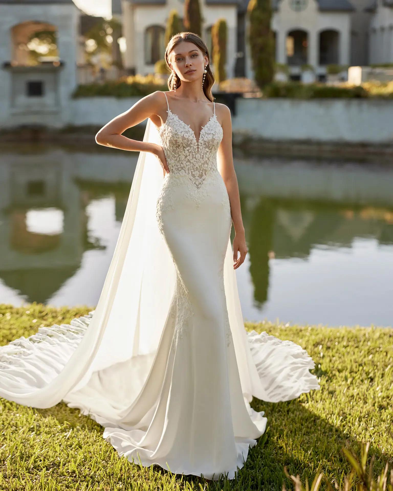 Elita wedding dress by Rosa Clara with detailed plunging neckline bodice spaghetti straps and long detailed train with a cape