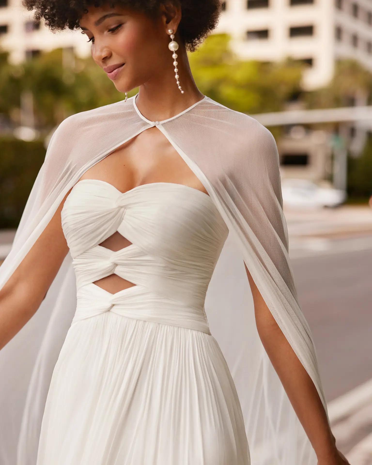 Kaily wedding dress by Rosa Clara in Columbus, Ohio with front bodice cutouts, bridal cape, and flowy chiffon skirt with a slit