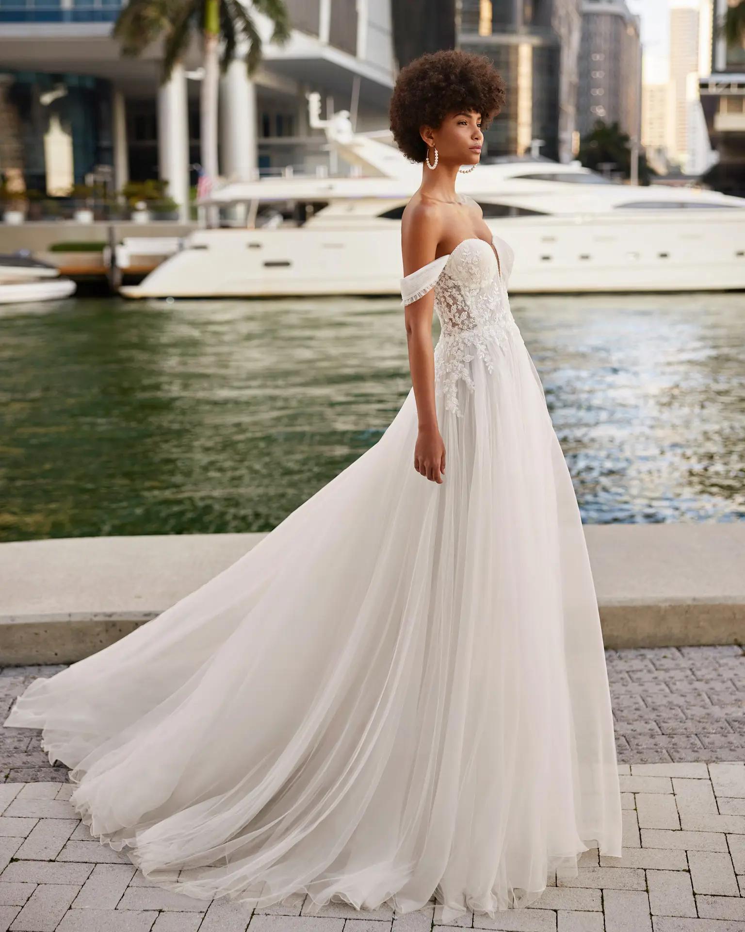 Killian wedding dress by Rosa Clara in Columbus, Ohio with off the shoulder details, flowy skirt and lace on corset bodice