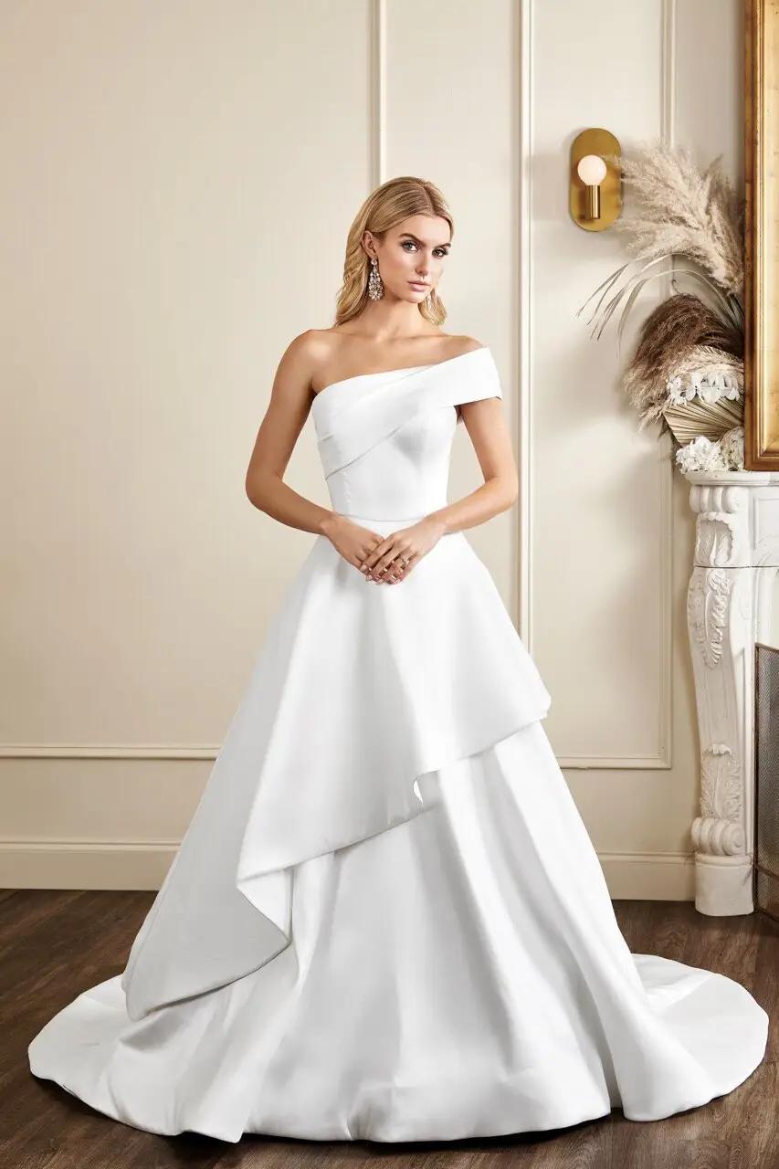 Crosby wedding dress with detachable one shoulder detail and asymmetrical hem on ballgown skirt