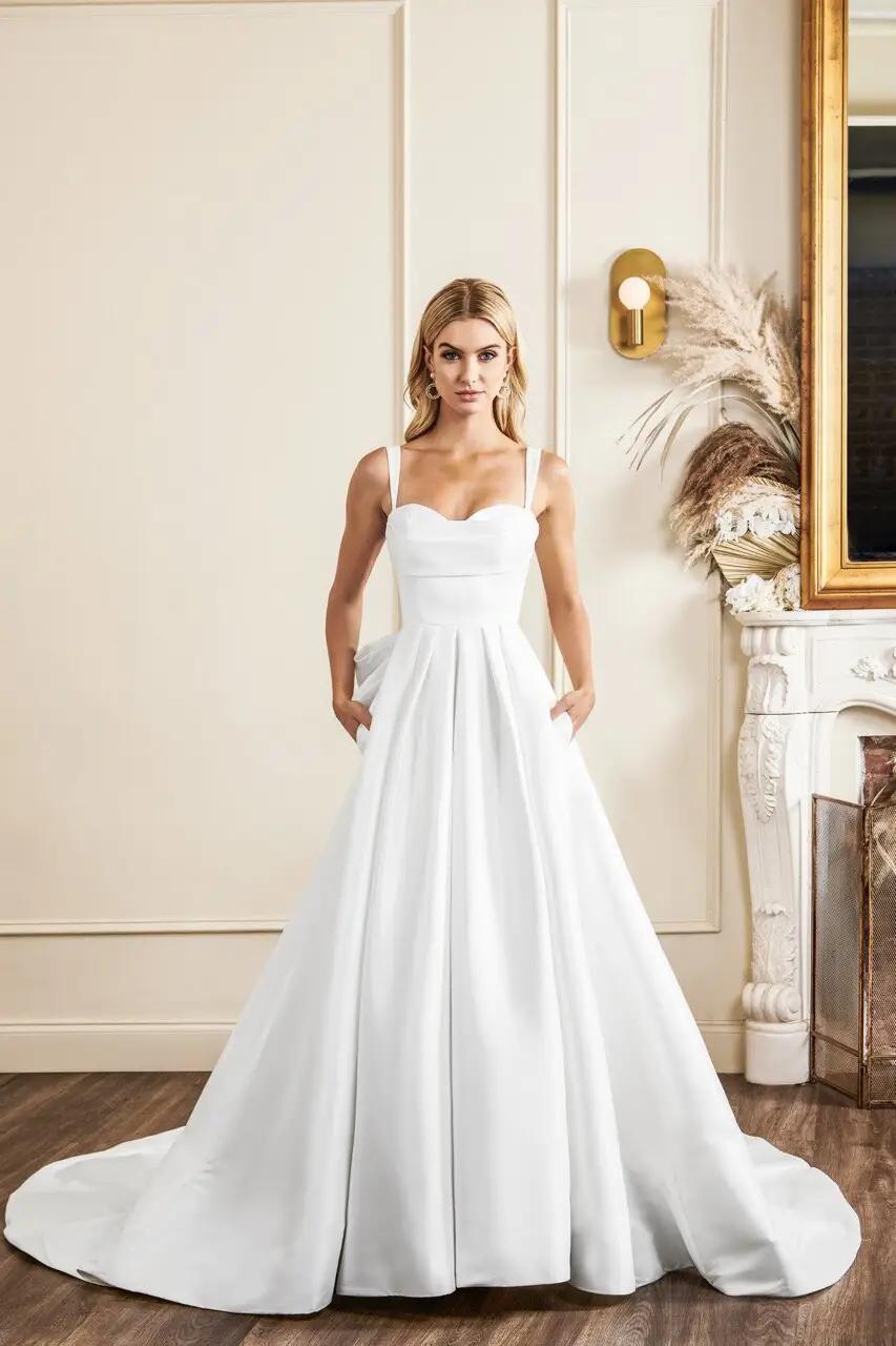 Sullivan wedding dress in Columbus, Ohio by Kelly Faetanini with sweetheart cowl neckline and pleated ballgown skirt, bow detail and wide straps